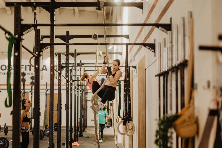 Athletes performing rope climb during Bodyweight Lab class