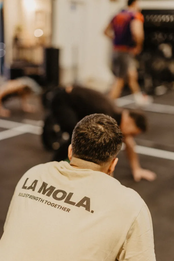 Coach wearing La Mola shirt supervising athlete training