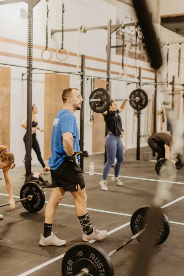 Group of athletes with Olympic barbells during Strength Club class
