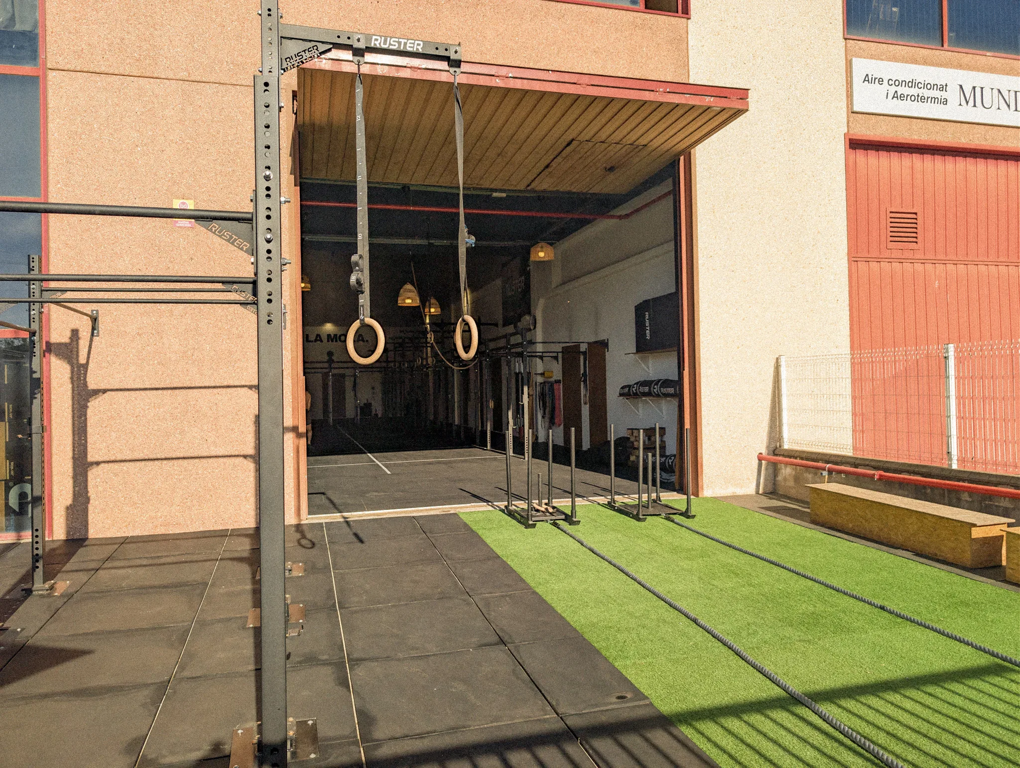 Zona exterior amb gespa artificial i rig per entrenar a l'aire lliure